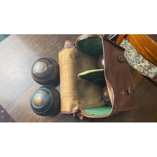 336 - Set of four vintage lawn bowls with carrying case, featuring distinctive markings and classic leathe... 