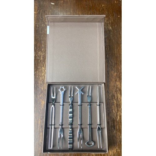 343 - Sambonet boxed cutlery set featuring seven stainless steel cocktail forks, each with unique designs.... 