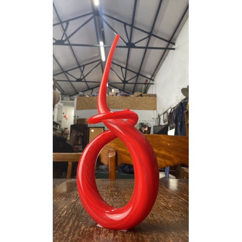 356 - Red glass sculpture featuring an abstract spiral design with a glossy finish.