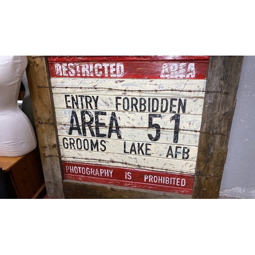 388 - Wooden sign displaying “Restricted Area 51” with barbed wire detailing. Rustic, vintage aesthetic re... 