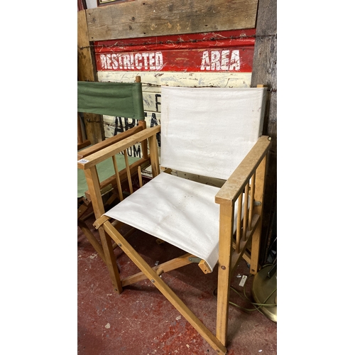 389 - 2 vintage directors' chairs with wooden frames and canvas seats with green and white covers.