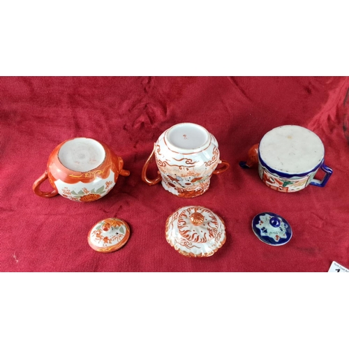 103 - Set of three Japanese teapots with vibrant hand-painted floral and figural designs, including two wi... 