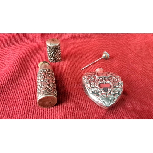 108 - Sterling silver perfume set featuring ornate floral embossed designs, including a heart-shaped bottl... 