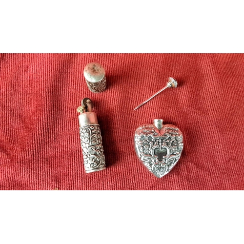 108 - Sterling silver perfume set featuring ornate floral embossed designs, including a heart-shaped bottl... 