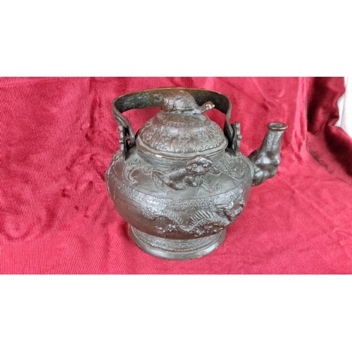 125 - Antique Oriental/ Chinese teapot with intricate dragon motifs and raised detailing, featuring a curv... 