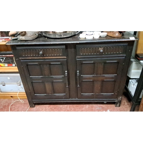 145 - Antique style dark-stained wood dresser with shelf display. Features decorative panelling and two lo... 