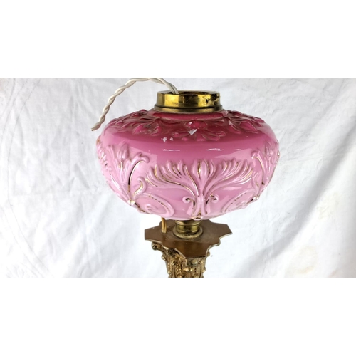 150 - Antique-style table lamp with pink embossed glass shade and ornate brass column base.