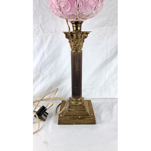 150 - Antique-style table lamp with pink embossed glass shade and ornate brass column base.