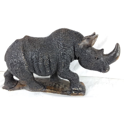 162 - A large stoneware rhino sculpture with textured detailing, capturing lifelike features and posture.