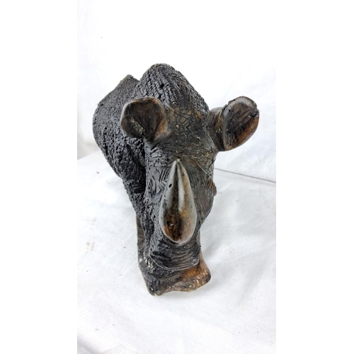 162 - A large stoneware rhino sculpture with textured detailing, capturing lifelike features and posture.