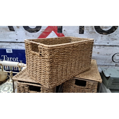 185 - Set of eight woven wicker storage baskets with metal frame.