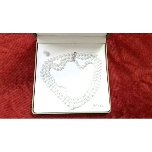 500 - Triple-strand pearl necklace with silver clasp, presented in a gift box.