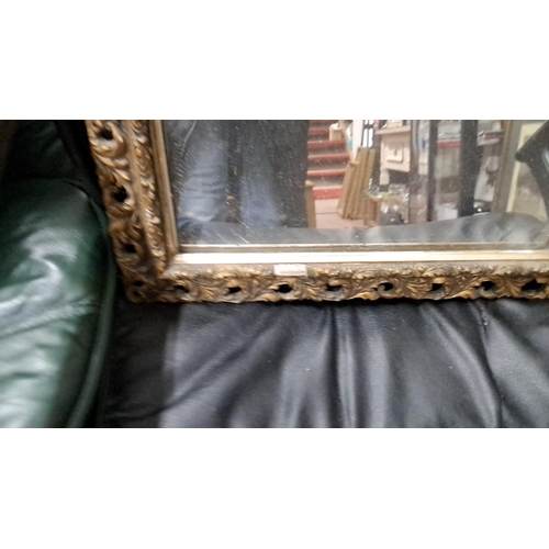 528 - Ornate vintage mirror with a carved gilt frame featuring scrolling leaf patterns, from the Victorian... 