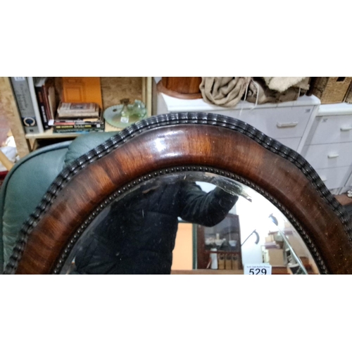 529 - Oval mirror with rich mahogany frame, featuring detailed beading along the edge. From late Victorian... 