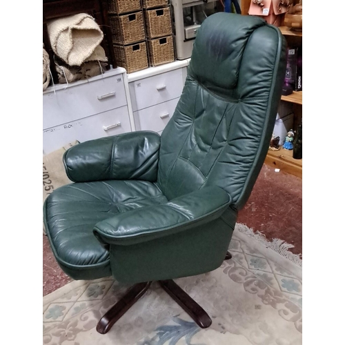 531 - Green leather swivel lounge chair with matching ottoman, featuring a padded backrest and wooden base... 