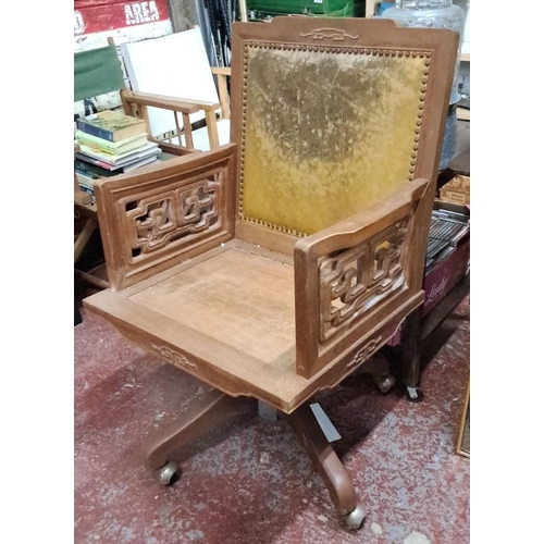 546 - Decorative Oak swivel chair featuring intricate lattice armrests and upholstered backrest.