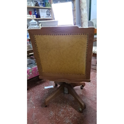 546 - Decorative Oak swivel chair featuring intricate lattice armrests and upholstered backrest.