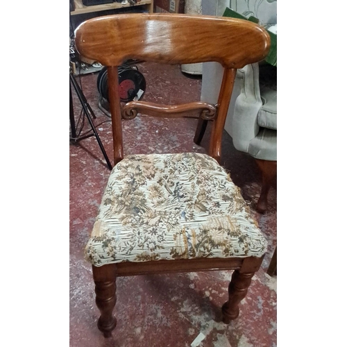 547 - Wooden chair with floral fabric upholstery, decorative carved details, and turned legs.