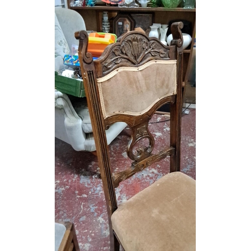 551 - Carved wooden side chair features floral motifs and an upholstered seat in beige fabric, from the la... 