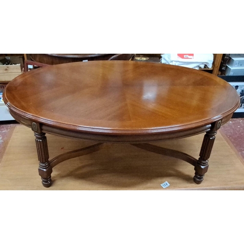 553 - Round mahogany coffee table with carved, fluted legs, and a rich, warm finish.