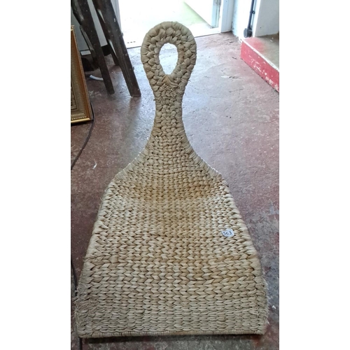 563 - Handwoven seagrass sled-shaped rocking chair, featuring intricate braided design.