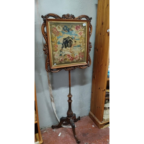 416 - Victorian walnut pole screen with a floral and dog motif tapestry panel. The frame features intricat... 