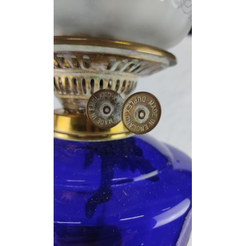 420 - Victorian brass oil lamp with ornate column base and cobalt blue glass font, featuring an etched gla... 