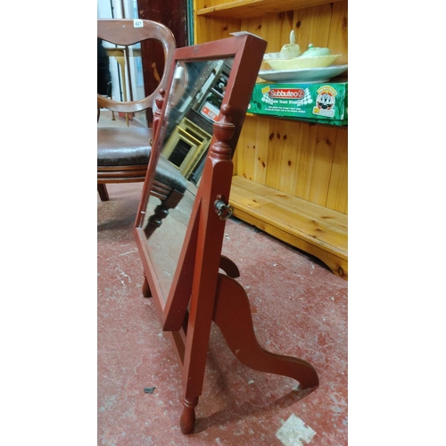 422 - Cheval mirror with red-painted wooden frame and stand, featuring turned finials.