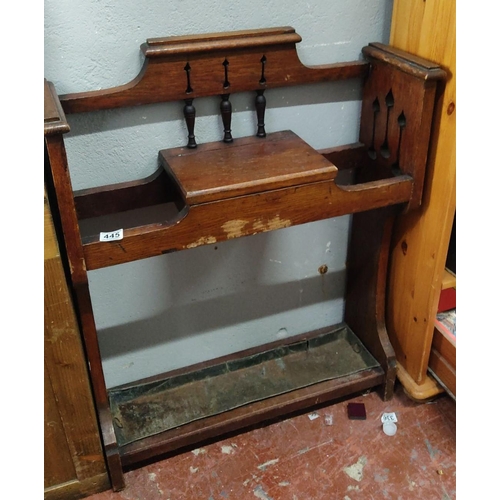 445 - Oak umbrella stand with pierced back and turned supports, featuring lower drip tray.