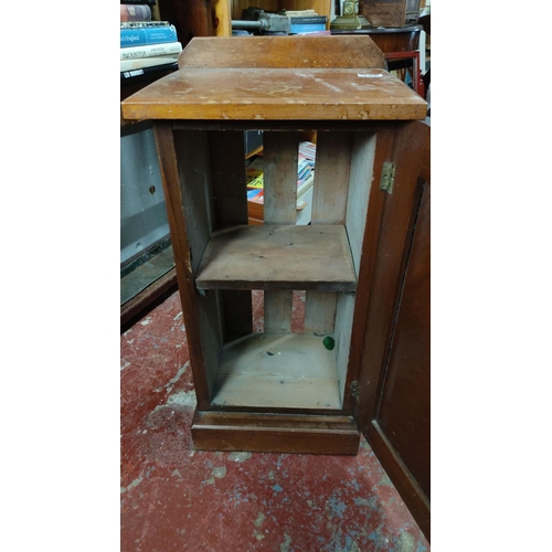 446 - Vintage wooden cabinet with a single hinged door and metal latch, featuring a flat top surface. From... 