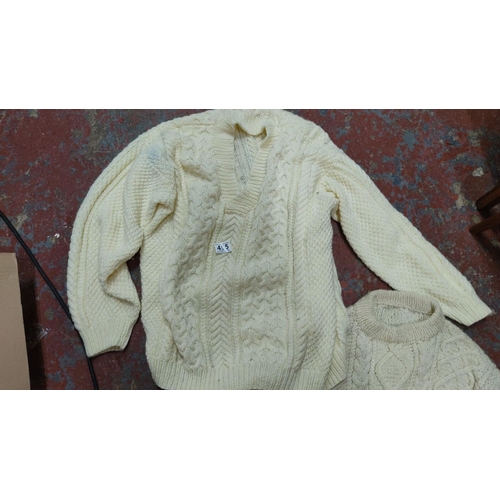 455 - Two cream Aran knit sweaters featuring traditional cable patterns, crafted from soft wool. Classic I... 