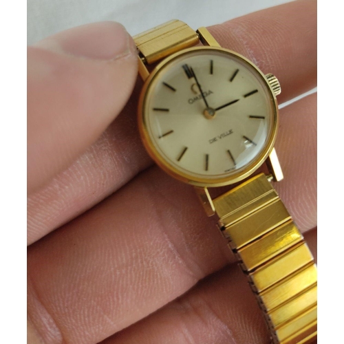 496 - Omega De Ville wristwatch in gold-tone finish features a classic dial with black markers. Comes in o... 