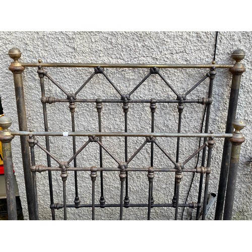 464 - An antique cast iron bed frame with hand painted details. 108x130cm