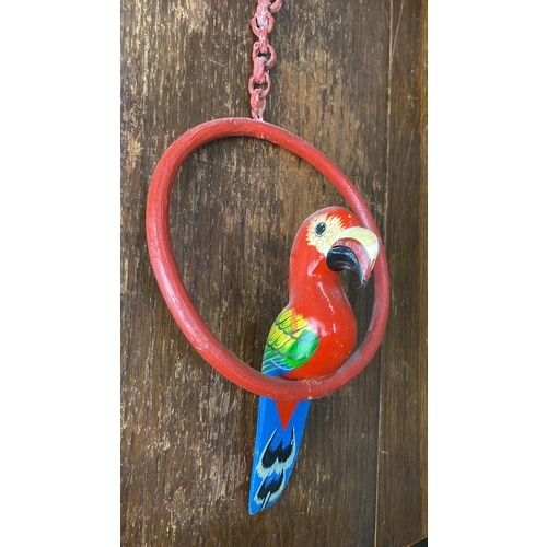 302 - Carved wooden parrot ornament has vibrant hand-painted details, a linked chain, and a circular perch... 