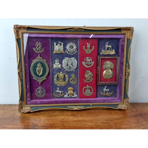 58 - A stunning framed display of Military cap badges.