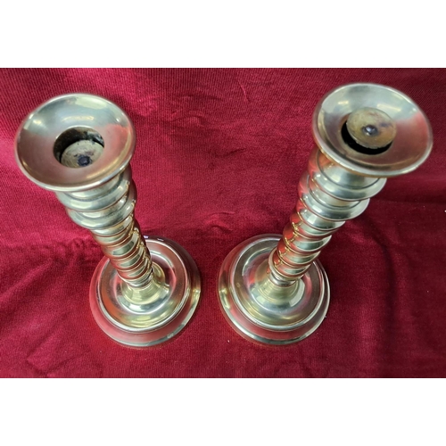 82 - A pair of vintage brass candlesticks with barley twist stems, each measuring 30cm tall.