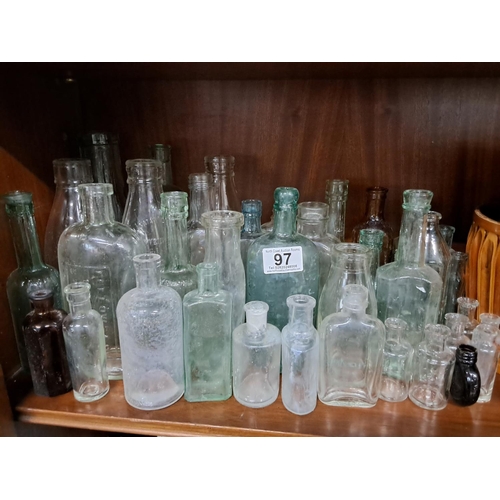 97 - A large assortment of antique glass bottles.