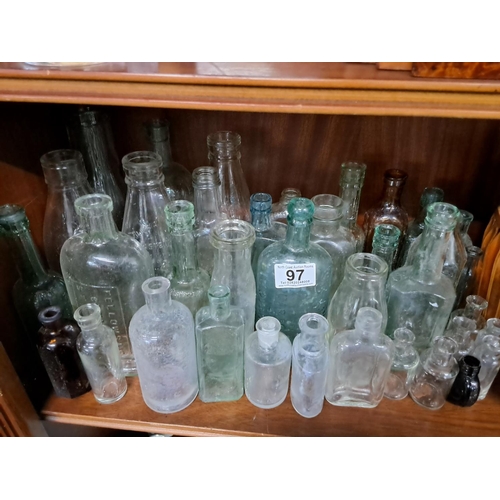 97 - A large assortment of antique glass bottles.