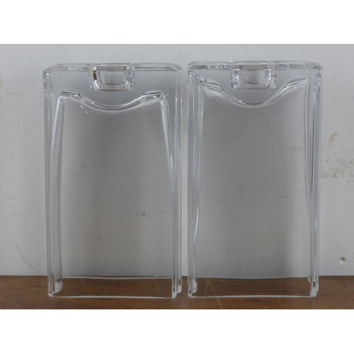 107 - A pair of modern glass candle holders, each measuring 20cm tall.