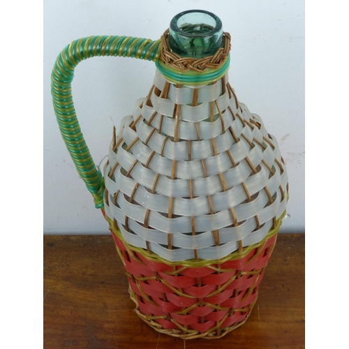 134 - A vintage jug with decoratively woven cover.