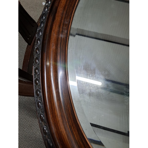 488 - An oval framed mirror with bevelled glass. Measuring 92x67cm.