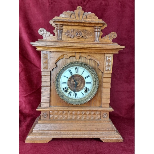 496 - An antique Ansonia clock in decorative wood case.