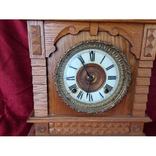 496 - An antique Ansonia clock in decorative wood case.