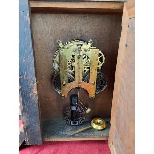 496 - An antique Ansonia clock in decorative wood case.