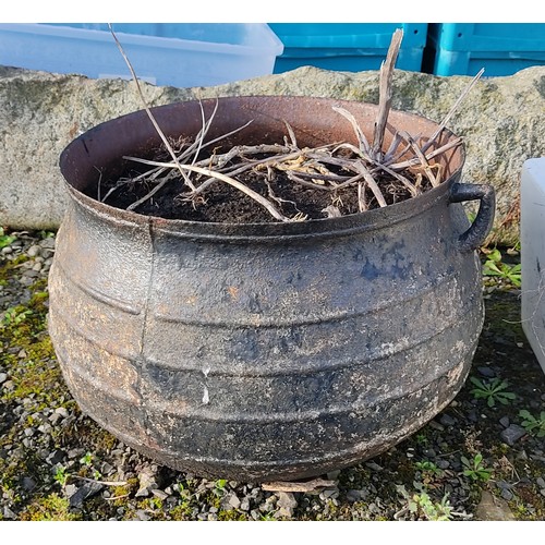 470 - A large cast metal three legged pot.