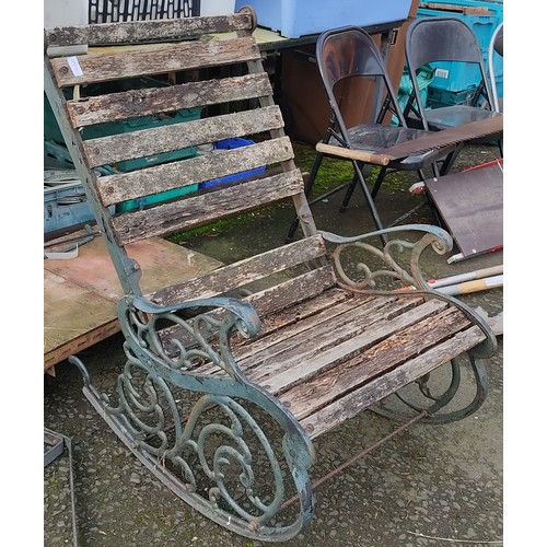 179 - An outdoor rocking chair with cat iron ends, in need of restoration.