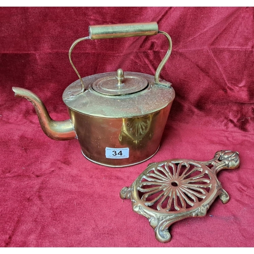 34 - An antique brass kettle & trivet.