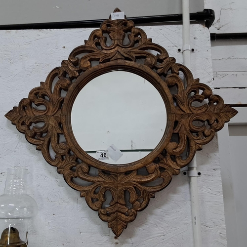 46 - A decorative wall mirror with highly carved wooden frame, measuring 65cm.