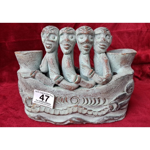 47 - An unusual clay figure, modelled as 4 figures in a boat.