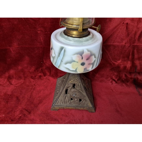 48 - An antique 'cottage' oil lamp, with decorative hand painted font, measuring 44cm tall.